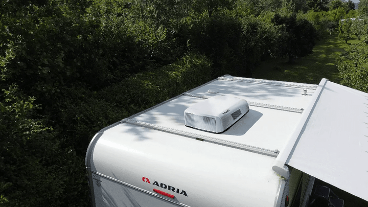 Mestic RTA-2600 rooftop air conditioner installed on a caravan roof in an outdoor setting.