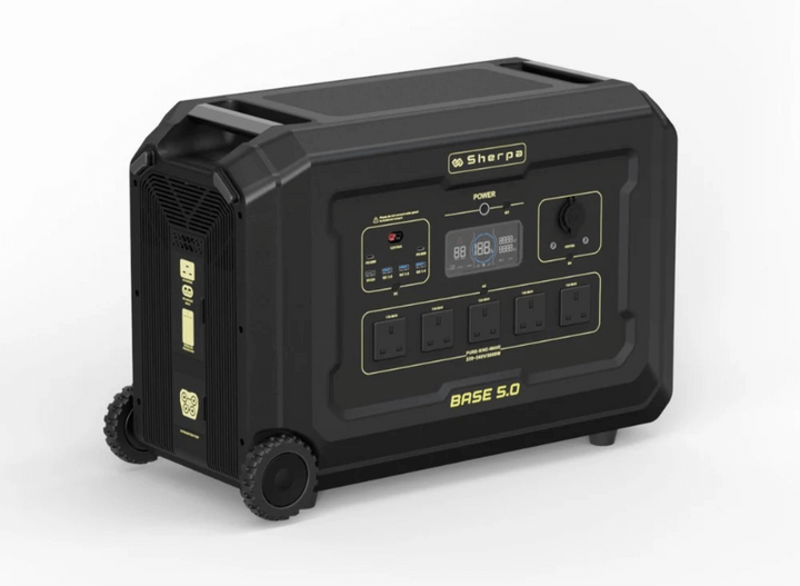 Front angled view of the Sherpa Base 5.0 portable power station – showing multiple AC outlets, USB ports, an LCD display, and control knobs on a rugged black chassis with wheels for easy transport, with white background.