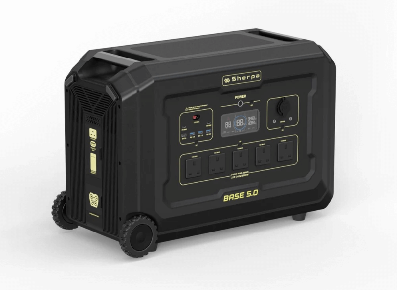Front angled view of the Sherpa Base 5.0 portable power station – showing multiple AC outlets, USB ports, an LCD display, and control knobs on a rugged black chassis with wheels for easy transport, with white background.