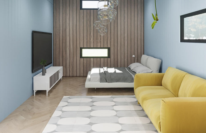 Scandinavian-style interior with a yellow sofa, wooden wall panels, minimalist decor, and a bed near large windows.