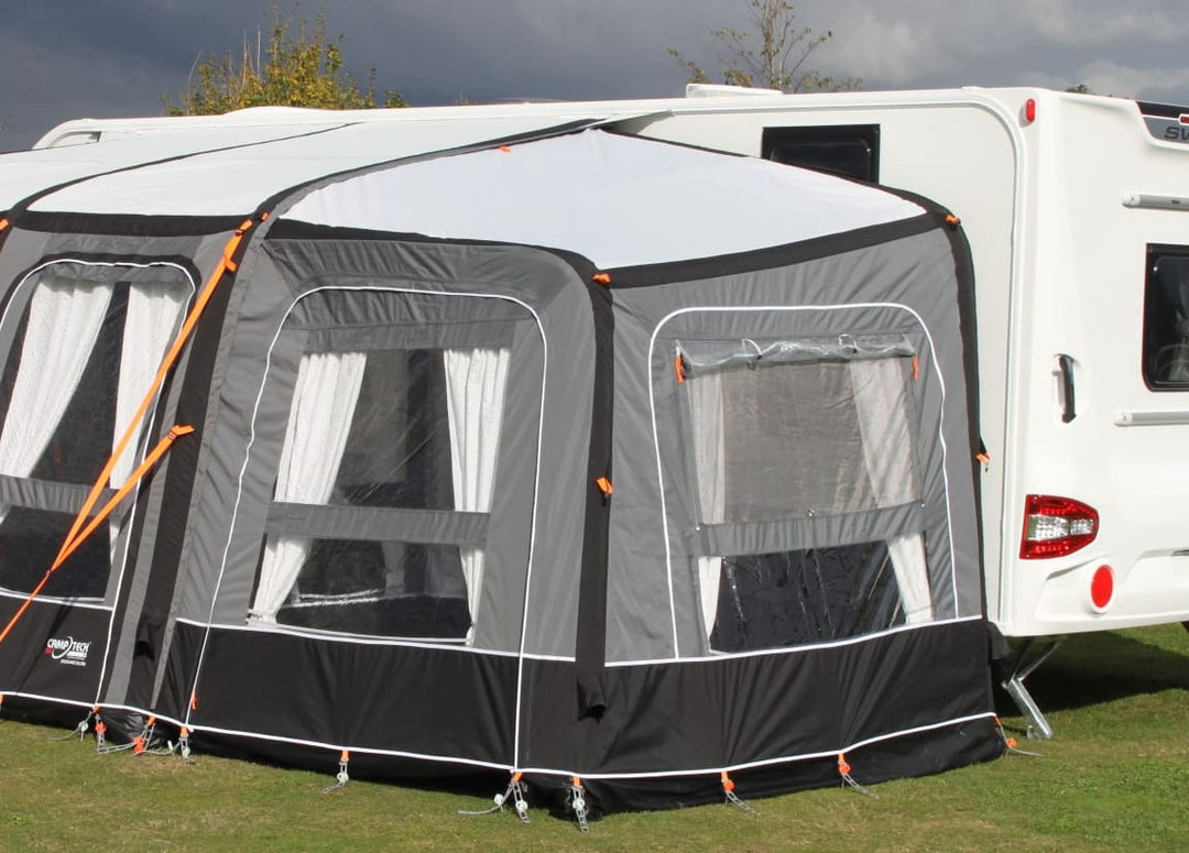 Camptech Starline Elite Infinity Pod in grey and black attached to a caravan on a grassy background.