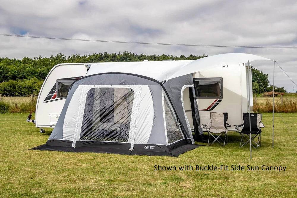 SunnCamp Swift Air 220 SC awning with a large covered entrance and clear window panels attached to a white Venus caravan, set on a grassy field beneath a partly cloudy sky.