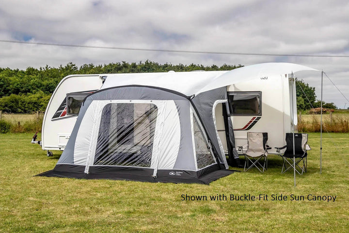 SunnCamp Swift Air 220 SC awning with a large covered entrance and clear window panels attached to a white Venus caravan, set on a grassy field beneath a partly cloudy sky.