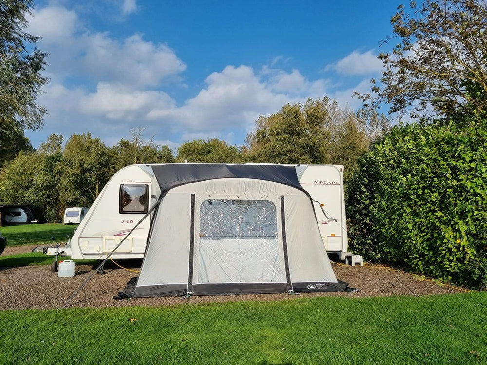 SunnCamp Dash Air 260 SC caravan awning viewed from the front, featuring a large clear window, dark roof panel, and grey fabric exterior.