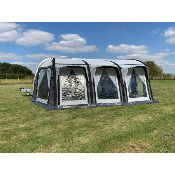 A Sunncamp Icon Air Awning front view highlighting the window design and structural framework, set against a natural backdrop with trees