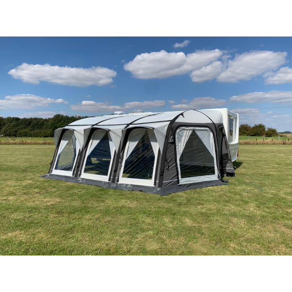 A Sunncamp Icon Air Awning viewed from the rear angle, displaying the full structure with four sections and black support beams against a blue sky