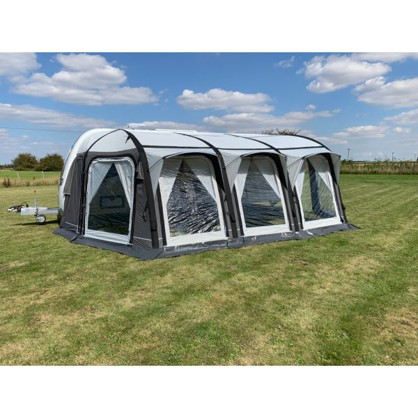 A Sunncamp Icon Air Caravan Awning with a detailed view of the transparent window panels and black structural supports, photographed against a sunny sky