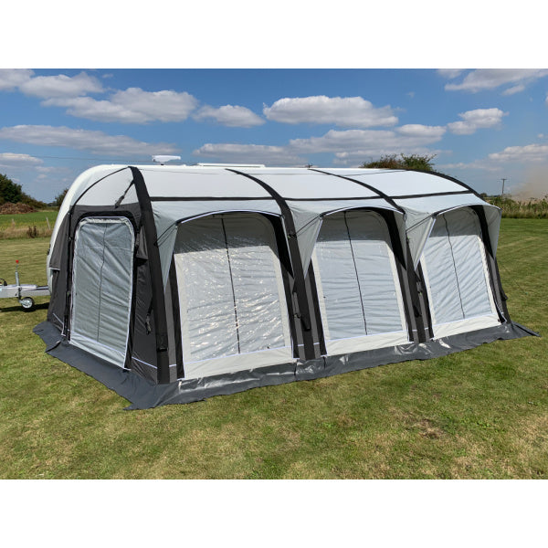 A Sunncamp Icon Air Caravan Awning with emphasis on the front window design, showing the clear panels and black structural supports against a blue sky