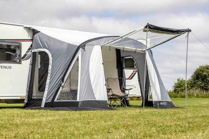 SunnCamp Swift Air 260 SC awning with an extended front sun canopy supported by poles, providing a shaded outdoor seating area beside a white caravan.