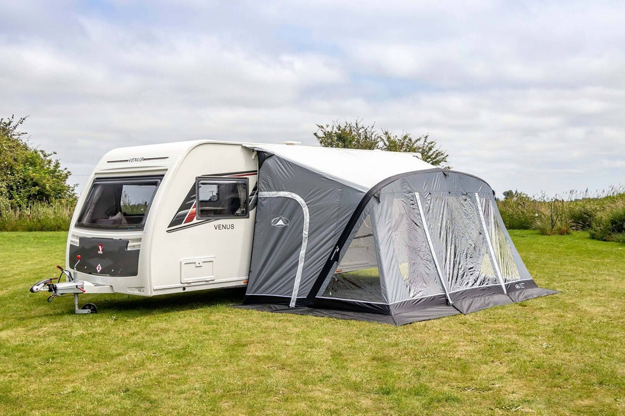 SunnCamp Swift Air 390 SC inflatable caravan awning attached to a white Venus caravan, featuring grey and white panels, clear front windows and a black groundsheet.