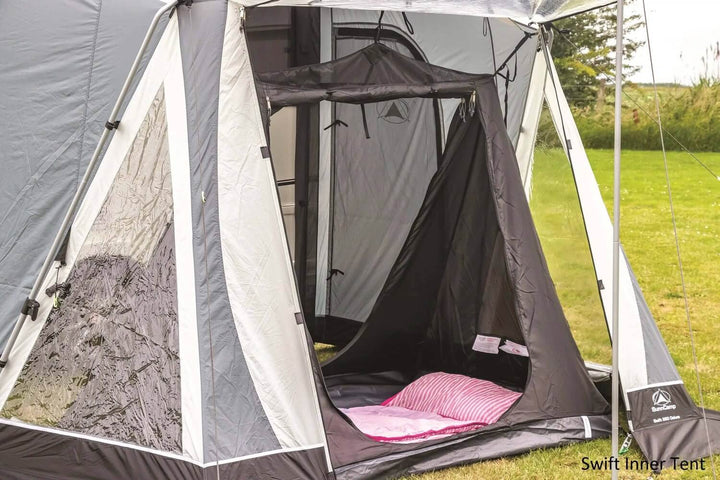 SunnCamp Swift Air 325 SC inner tent with a black zippered doorway, grey fabric walls and pink bedding inside the caravan awning.