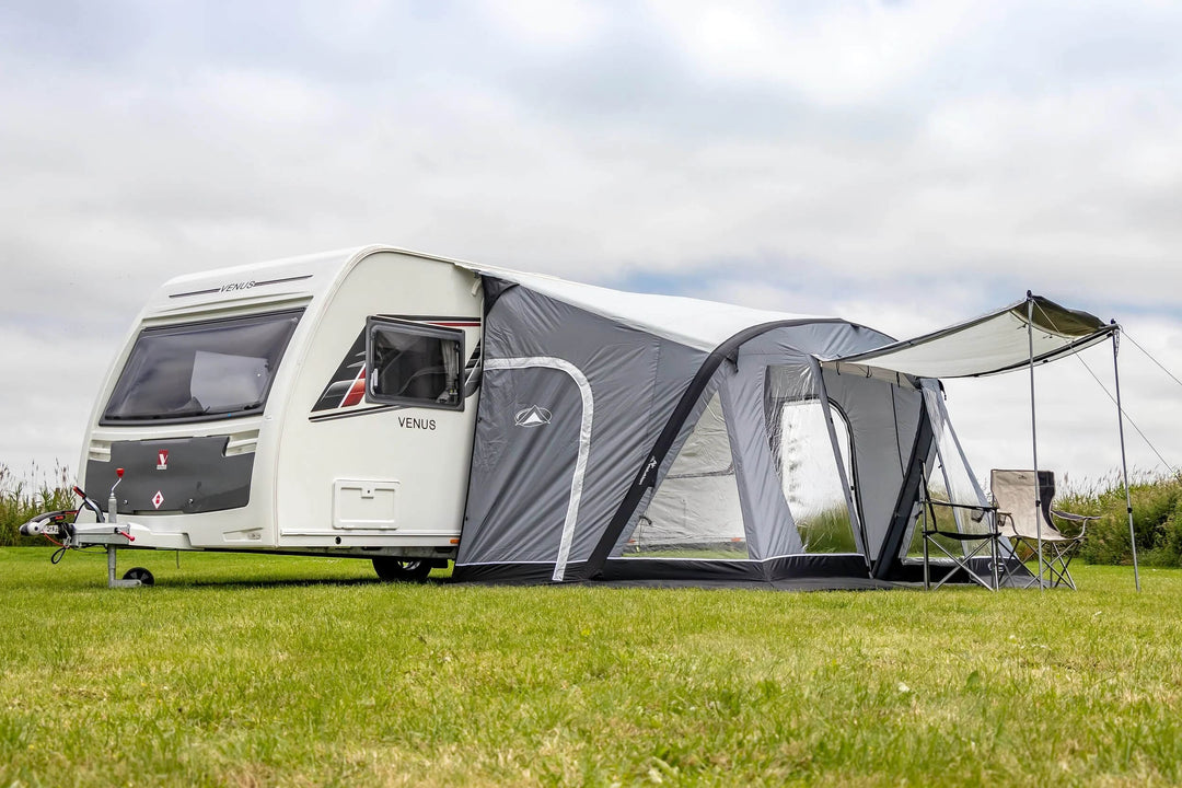 SunnCamp Swift Air 390 SC awning with an extended buckle-fit side sun canopy providing additional shade beside a white caravan.