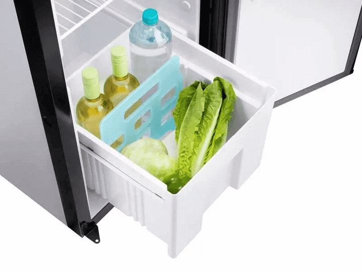 Thetford N4142A Flat Frame fridge drawer open with green lettuce, cabbage, two yellow-capped bottles, and a water bottle inside, on a white background.

