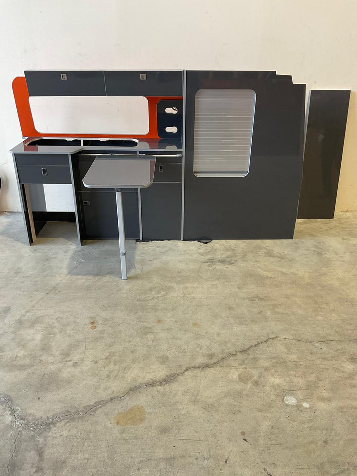 Vauxhall Vivaro Campervan Kitchen Unit Bespoke gloss white kitchen conversion unit with overhead lockers and pull-out table, shown in a workshop setting.
