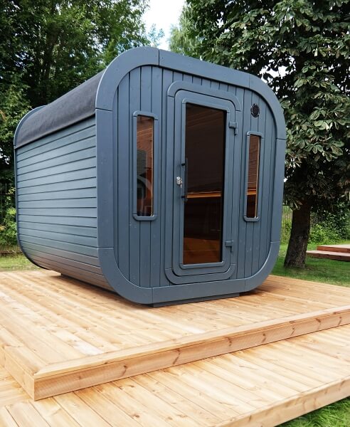 Front angled view of Viking Industrier Luna Outdoor Sauna 2.3 x 2.4m on a wooden platform with front door and windows. 
