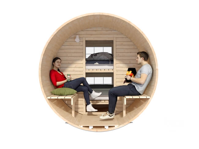 Front-facing interior view of Viking Industrier 2.2 x 3.3m Sleeping Barrel showing two people sitting on benches and bunk beds in the background, on a white background.