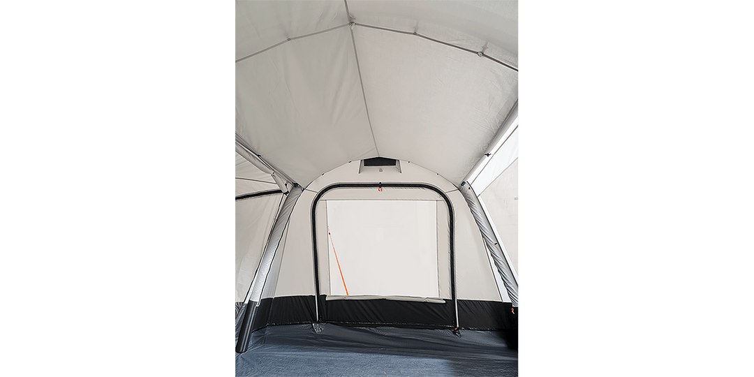 Interior view of the Starcamp Voyager Air awning on a black background, showcasing the spacious white fabric interior, arched doorway, black lower panels, and groundsheet.