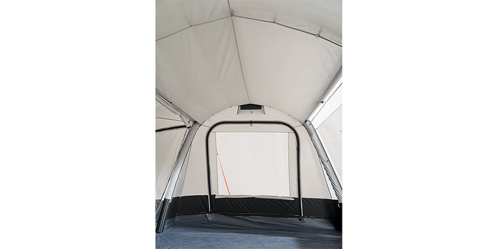 Interior view of the Starcamp Voyager Air awning on a black background, showcasing the spacious white fabric interior, arched doorway, black lower panels, and groundsheet.