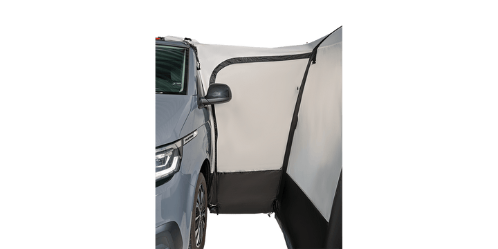 Close-up view of the Starcamp Voyager Air awning attachment to a grey campervan on a black background, highlighting the fabric connection, structural seams, and black lower panels.
