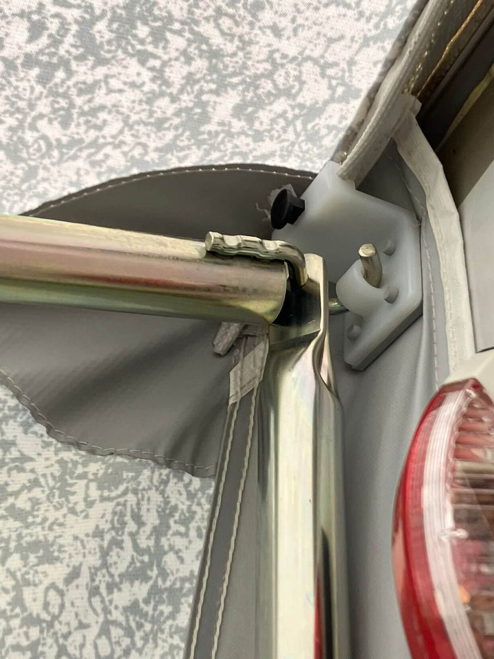 Walker Hobby Beachy Awning pole bracket mounted near caravan rear light for secure installation.