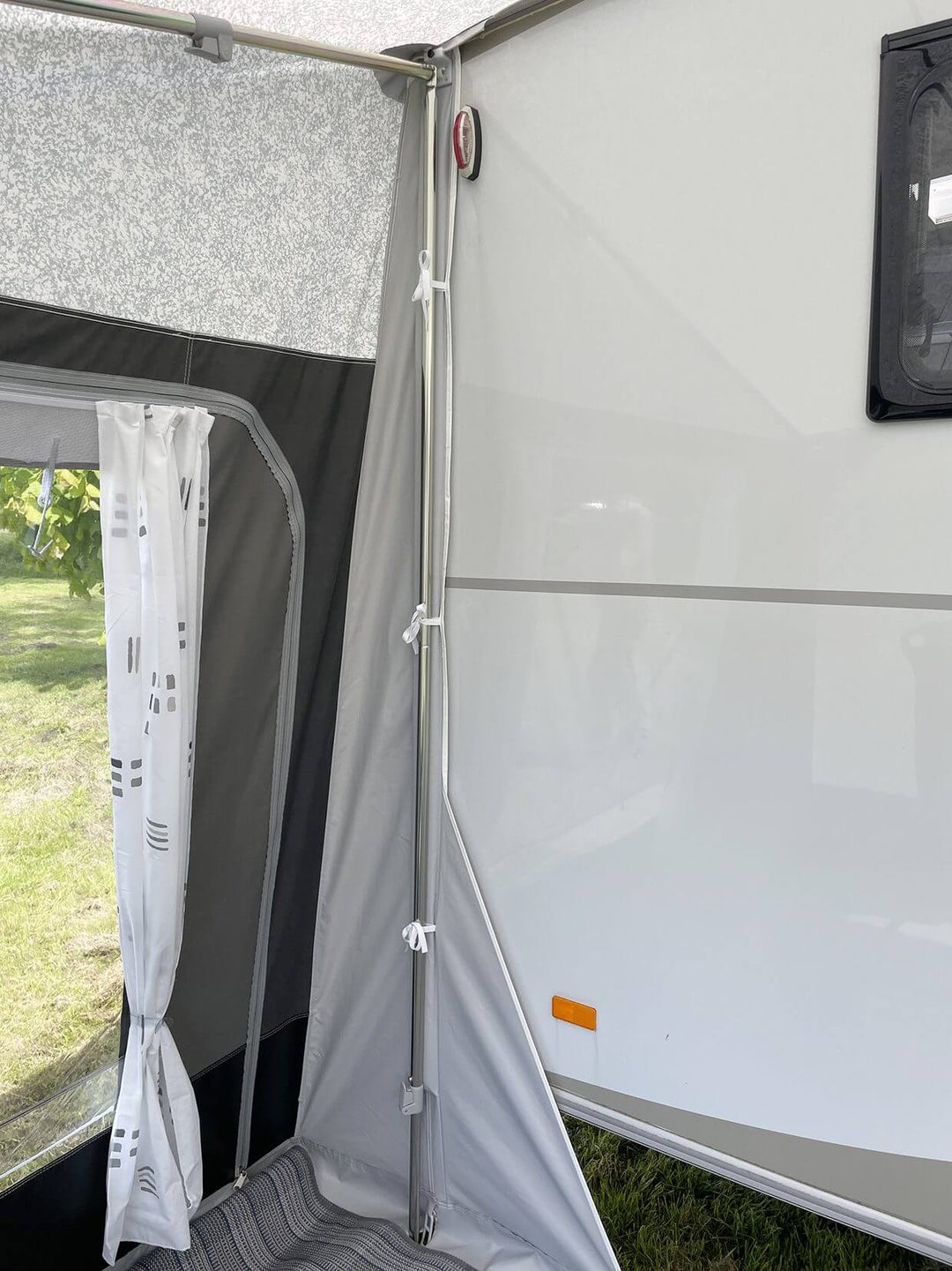 Walker Beachy Awning interior with tied poles, window curtains, and groundsheet flooring.