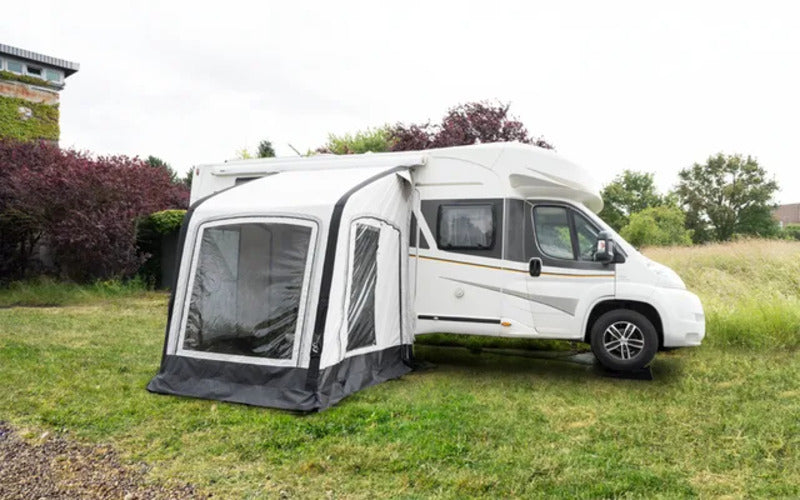 Westfield Vega 200 motorhome porch awning set up beside a white campervan on a grassy camping pitch.